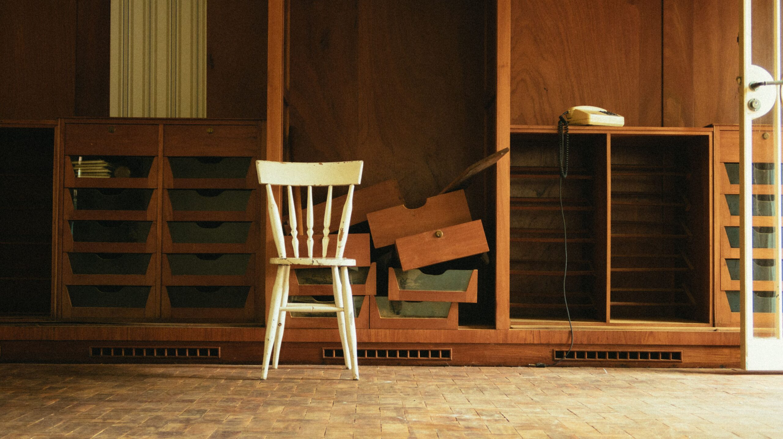 A vintage wooden interior featuring a single white chair and rustic decor.